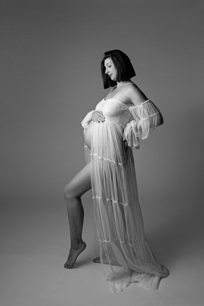 Zwangere vrouw in witte jurk tijdens een zwangerschap fotoshoot bij Little Miracle memories