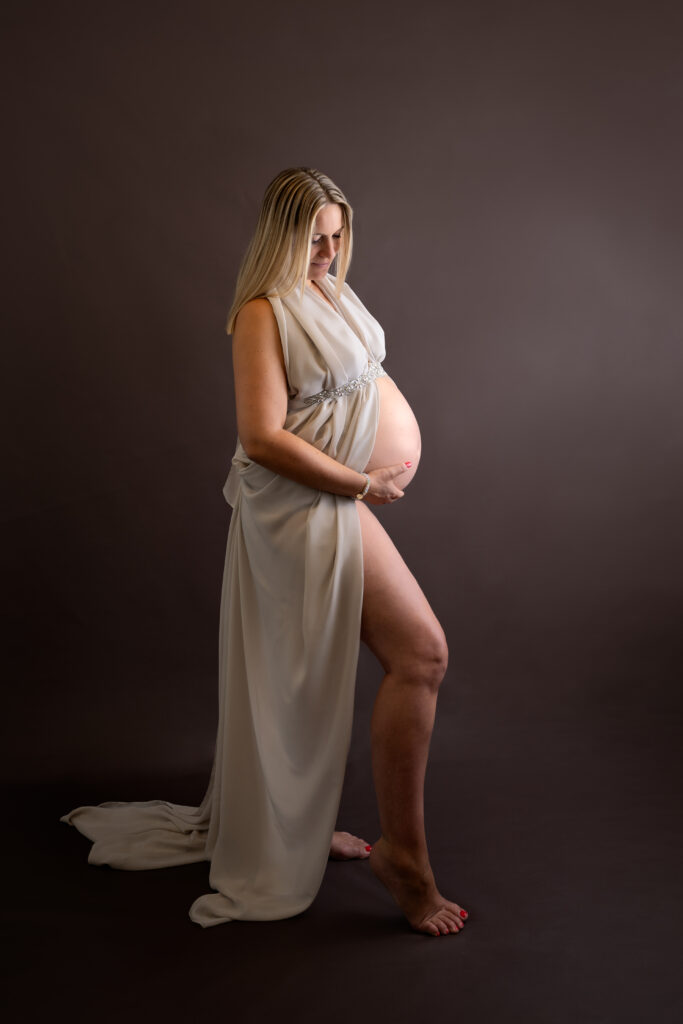 Zwangere vrouw in zand kleurig outfit tijdens een zwangerschap fotoshoot bij Little Miracle memories