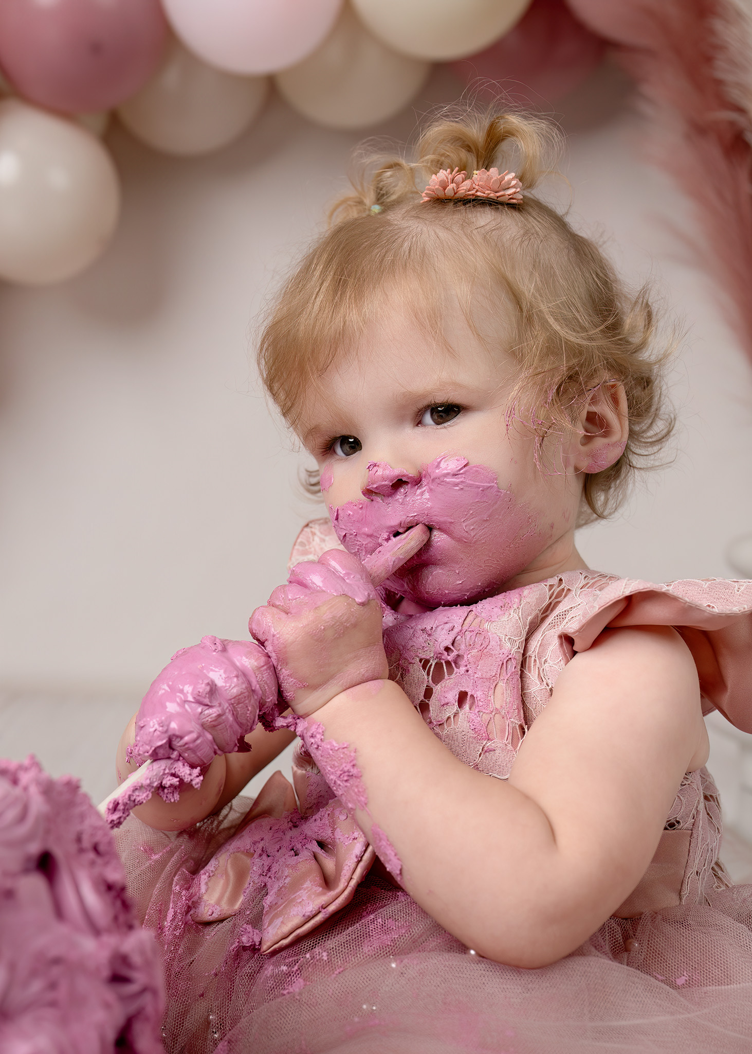 Baby viert zijn eerste verjaardag tijdens een cakesmash fotosessie met teddybeer, witte taart en zachte studio achtergrond in Zandhoven